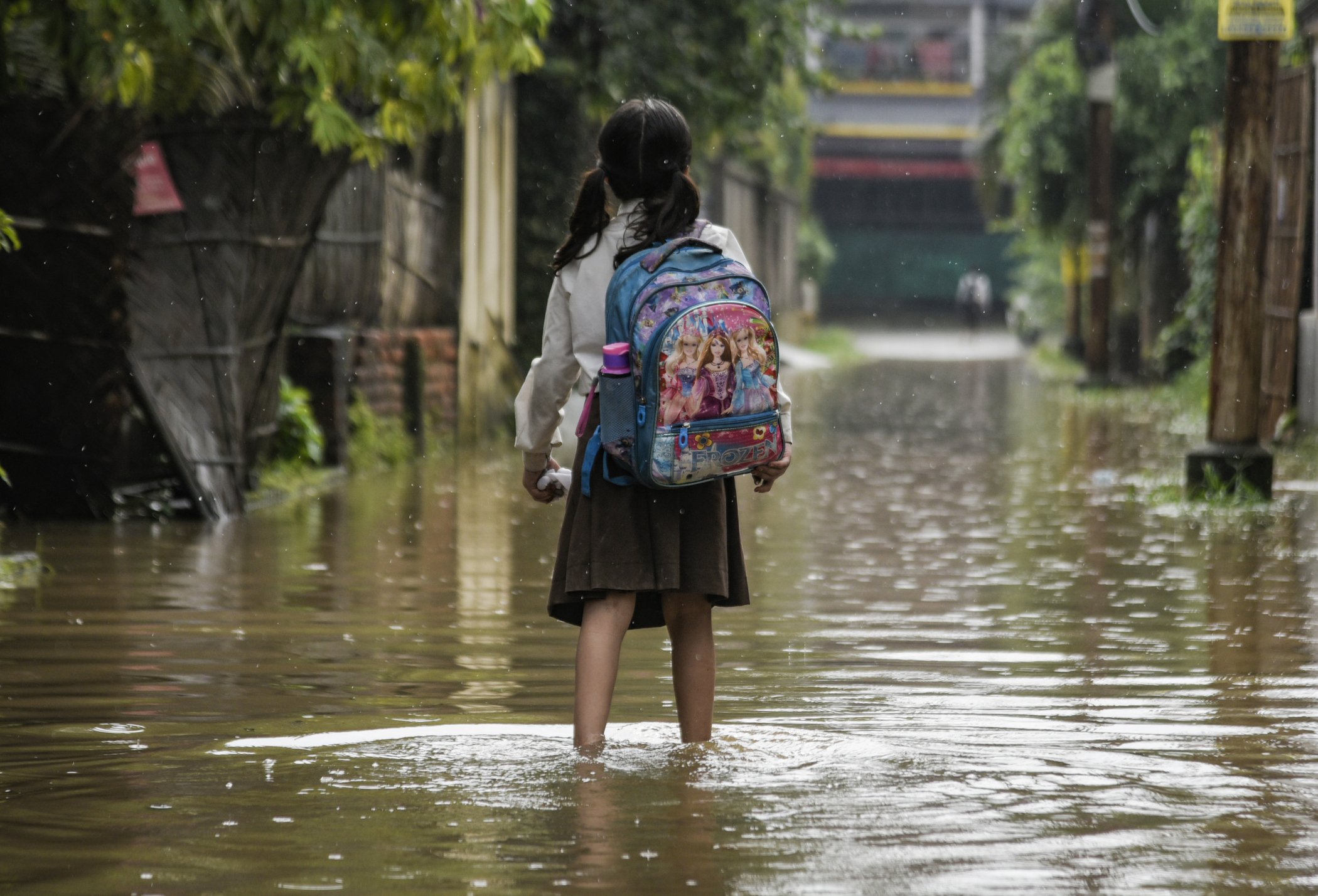 Girl wades through flood waters in India. Photo: iStock.