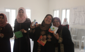 Women participants in Qalqiliyah holding information brochures on how to receive medical support via the 121 Helpline - photo credit- Omar A