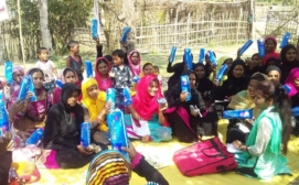 Distribution of sanitary napkins by IDF youth leader during a group meeting with young girls in Assam