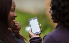 Two women exploring WhatsApp on MomConnect (Dark City, South Africa)