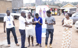 Global Health Economics Ltd -  Woman district/area representative (on the right) launching the family planning benefits card in Kifumbira slum community, Kampala, Uganda.