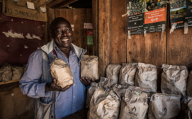 A distributor poses with Sanivation’s charcoal briquettes.